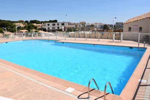 une grande piscine avec de l'eau bleue dans l'établissement Super studio pour 4 à proximité des plages, à Sausset-les-Pins