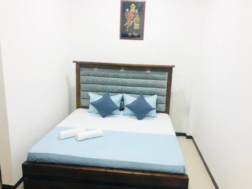a bedroom with a bed with blue pillows at Mario Family Villa and Restaurant in Negombo