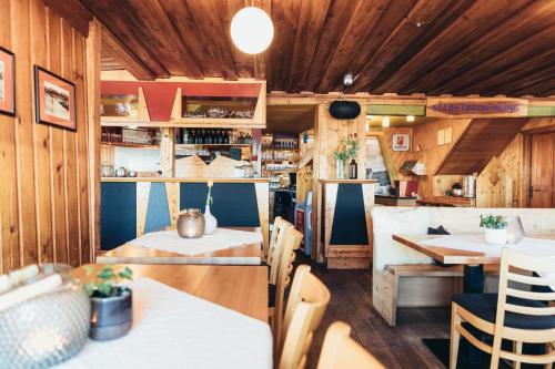 a kitchen and dining room with wooden walls and tables at Alpinhotel Pacheiner in Treffen