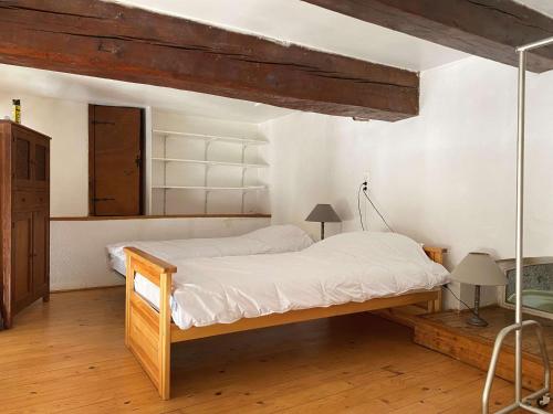 - une chambre avec un lit doté d'un cadre en bois dans l'établissement Appartement T3 au calme avec extérieur privatif, proche étang, tout équipé, 3 chambres. - FR-1-553-86, à Balaruc-les-Bains