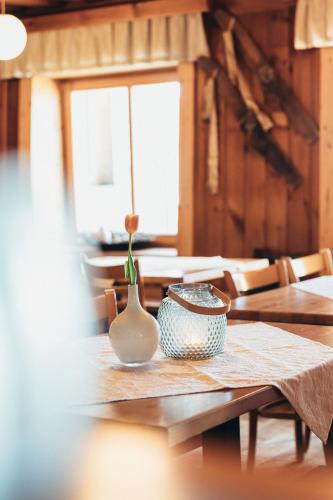 a table with a vase and a bowl on it at Alpinhotel Pacheiner in Treffen