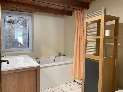 une salle de bain avec une baignoire et un lavabo dans l'établissement Appartement T3 au calme avec extérieur privatif, proche étang, tout équipé, 3 chambres. - FR-1-553-86, à Balaruc-les-Bains