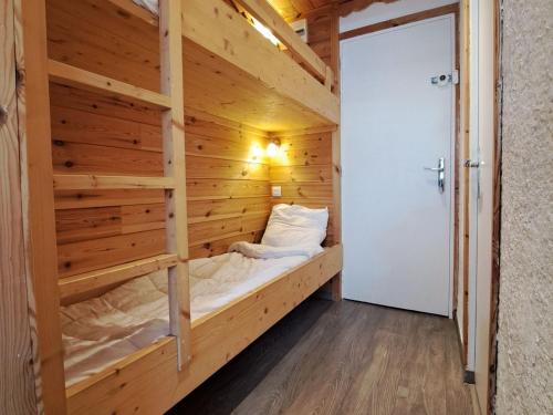 une chambre avec un lit dans un mur en bois dans l'établissement Studio rénové pied des pistes à Pra-Loup 1600 - FR-1-165A-29, à Uvernet