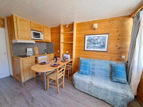 Cet appartement comprend une chambre avec une table et un lit ainsi qu'une cuisine. dans l'établissement Studio rénové 4 pers. pied des pistes à Pra-Loup 1600, balcon, équipements complets - FR-1-165A-29, à Uvernet