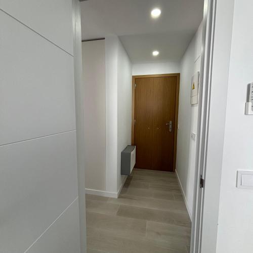 a hallway with white walls and a wooden door at Casa Francisca 100 mt from the beach By lucaproperties in Puerto Rico de Gran Canaria