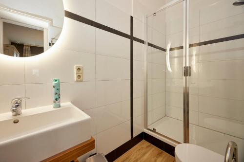a white bathroom with a sink and a shower at BnB-SiZ in Zeltingen-Rachtig