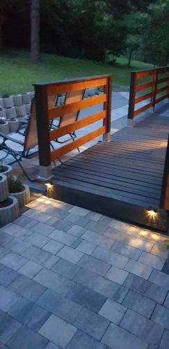a wooden bridge with lights on a patio at Szalonka Vendégház Kemence in Kemence