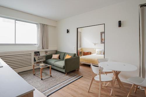 un salon avec un canapé, un lit et une table dans l'établissement Appartement moderne et chic proche Tour Eiffel, à Paris