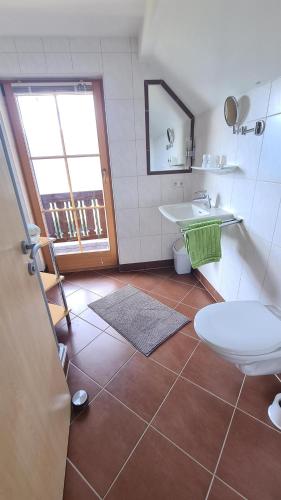 a bathroom with a toilet and a sink at Waldherrhof in Aich