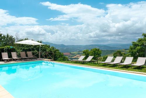 a swimming pool with lounge chairs and an umbrella at Nikis Resort in Gubbio