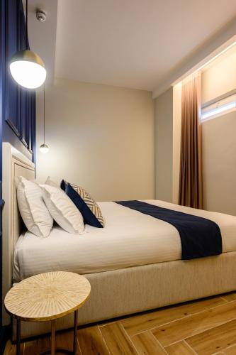 a bedroom with a large bed and a table at XVI Suites - Adults Only in Naxxar