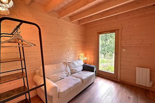 a living room with a couch in a log cabin at Chalet Caroubier - Chalet avec vue montagne in La Bresse