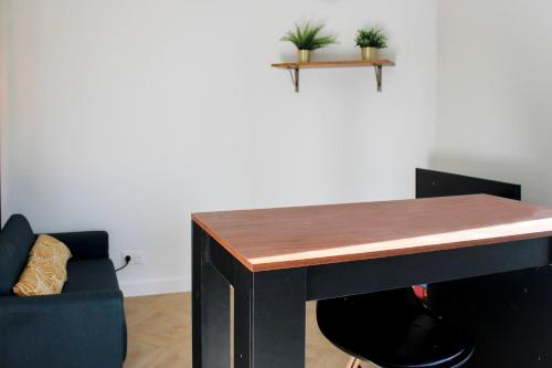 une table dans une pièce avec une chaise et un canapé dans l'établissement Practical and pleasant 20 m studio, à Montreuil