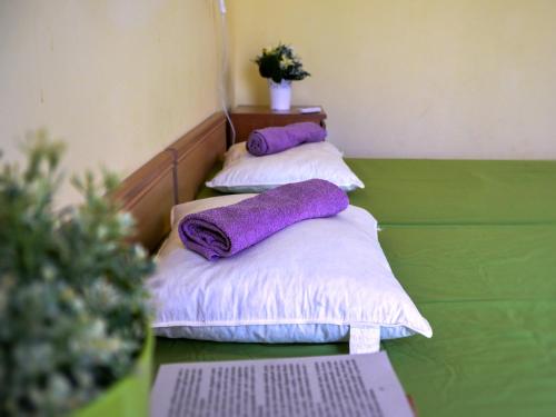 three pillows on a bed with purple pillows at Apartments Anna in Zadar