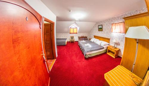 a bedroom with a bed and a red carpet at Borhotel Sziluett Farkasmály in Gyöngyös