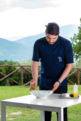 a man preparing a bowl on a table at Nikis Resort in Gubbio