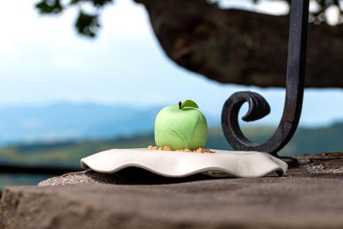 a green apple sitting on top of a plate at Nikis Resort in Gubbio