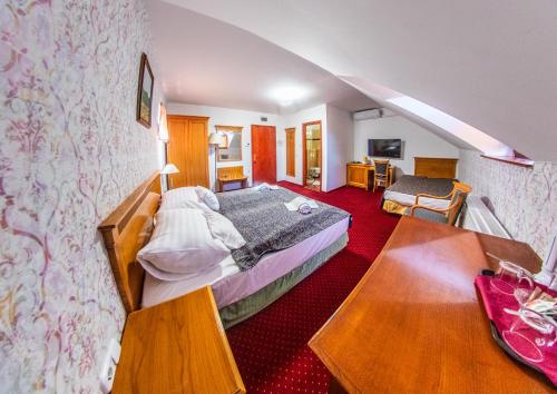 a hotel room with two beds and a table at Borhotel Sziluett Farkasmály in Gyöngyös
