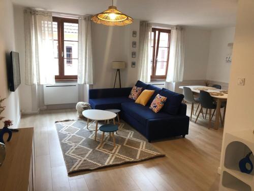 ein Wohnzimmer mit einem blauen Sofa und einem Tisch in der Unterkunft Les 4 vents in Belfort