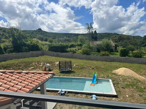 a backyard with a swimming pool and a playground at Magnifique villa proche ruoms vallon pont darc in Grospierres