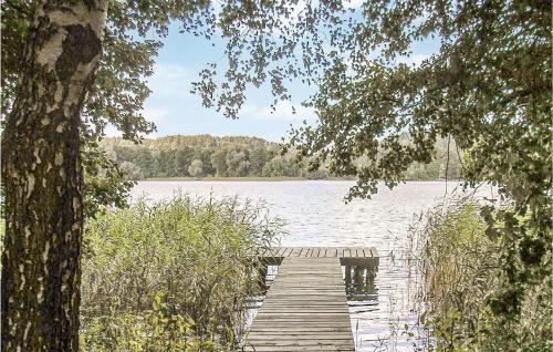 a wooden dock on a lake with a sail boat at Holiday Home Mragowo Sniadowo in Kosewo