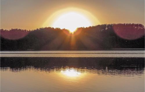 a sunset over a body of water with the sun setting at Holiday Home Mragowo Sniadowo in Kosewo