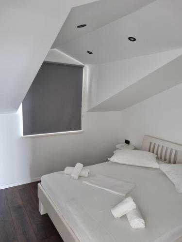 a white room with two beds and a mirror at Villa Mila in Bol