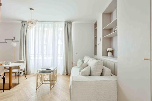 un salon blanc avec un canapé blanc et une table dans l'établissement Romantic Getaway - Le Marais - with AC, à Paris