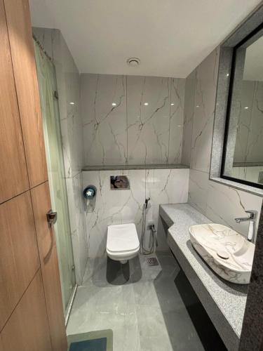 a bathroom with a toilet and a sink at RED CARPET CLASSIC HOSPITALITY LLP in Māndvi