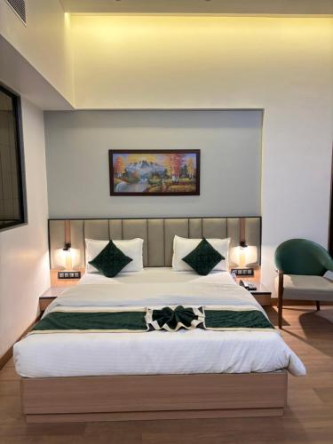a bedroom with a large bed and a green chair at RED CARPET CLASSIC HOSPITALITY LLP in Māndvi