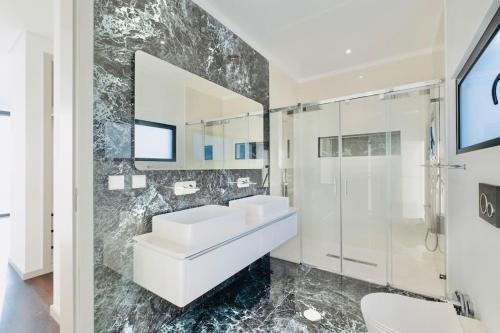 a bathroom with two sinks and a shower at Vila Cales e Chadas by Your Madeira Rentals in Arco da Calheta