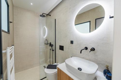a bathroom with a sink and a toilet and a mirror at Villa Danai in Gouvia