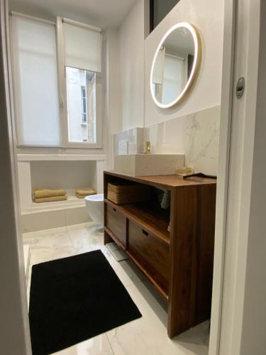 une salle de bain avec un lavabo, des toilettes et un miroir dans l'établissement Appartement neuf design - Montmartre, à Paris
