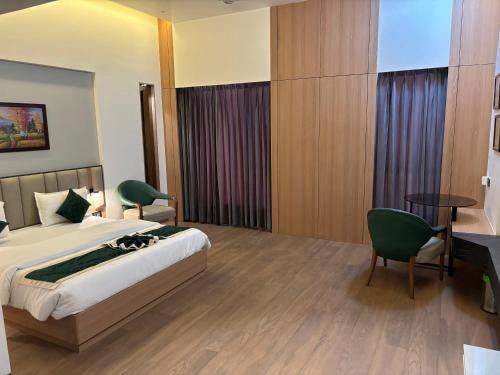 a bedroom with a bed and a table and chairs at RED CARPET CLASSIC HOSPITALITY LLP in Māndvi