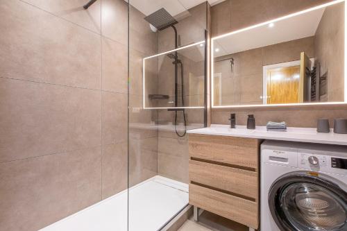 La salle de bains est pourvue d'un lave-linge et d'une douche. dans l'établissement Appartement Moderne au Cœur d'Annecy - À Deux Pas du Lac et de la Vieille Ville, à Annecy