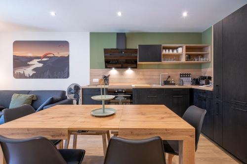 une cuisine avec une table et des chaises en bois dans l'établissement Appartement Moderne au Cœur d'Annecy - À Deux Pas du Lac et de la Vieille Ville, à Annecy