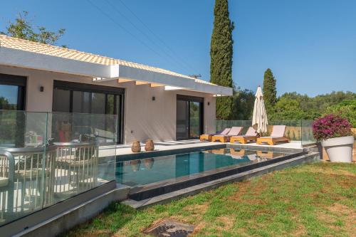 a house with a swimming pool in the yard at Villa Danai in Gouvia