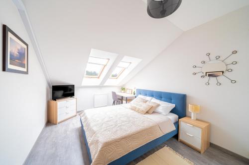 ein Schlafzimmer mit einem Bett mit blauem Kopfteil in der Unterkunft Lulu Apartments - NoMoreRain - Apartament 2-pokojowy Grzybowo - klimatyzacja, Netflix in Grzybowo