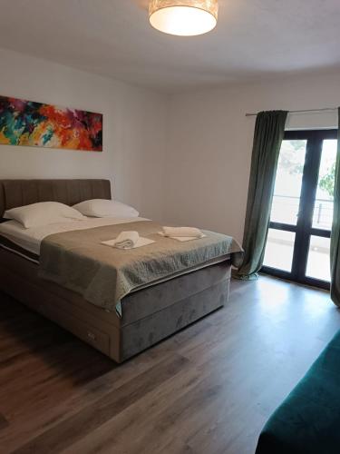 a bedroom with a bed and a large window at LEGIN in Živogošće