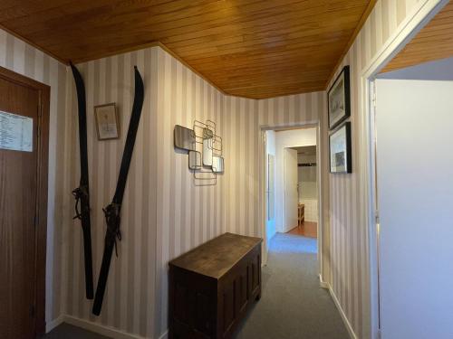 un couloir avec des skis au mur et un plafond en bois dans l'établissement Homency - Résidence de l'Oisans C5, à L'Alpe-d'Huez