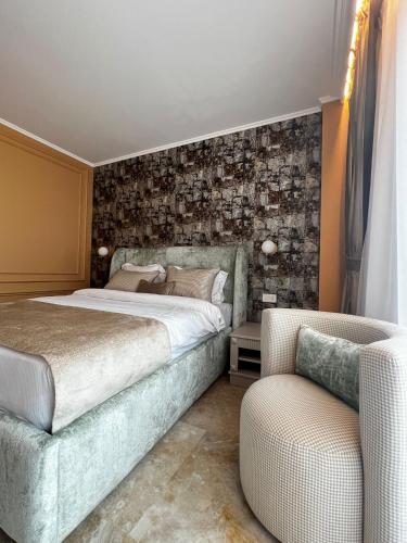 a bedroom with a bed and a couch and a chair at Boutique Hotel Balș in Balş