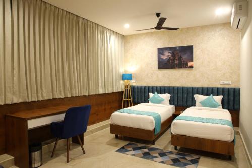 a hotel room with two beds and a desk at Zing Rooms by GuestHouse Suites in Bengaluru