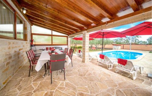 LisičićiにあるAwesome Home In Lisicic With Wifiのテーブルと椅子とプールのあるパティオ