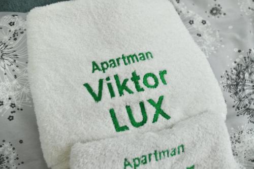 a white towel with the words atthen vida lix on it at Apartman Viktor LUX in Kragujevac