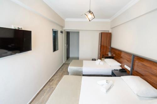 a hotel room with two beds and a flat screen tv at Marka Hotel in Antalya