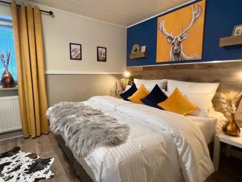 a bedroom with a white bed with a deer painting on the wall at Luxuriöses, renoviertes Haus mit Garten, Gratis WLAN, Hund willkommen in Zandt