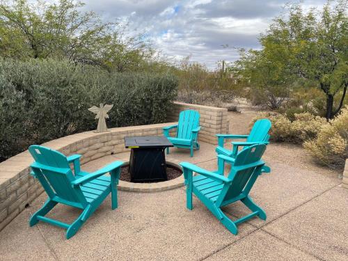 three blue chairs and a table with a fire pit at Adventure and Serenity in Litchfield Park Sleeps 8 in Litchfield Park