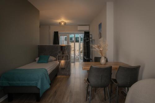 a bedroom with a bed and a table and chairs at Hotel Groede in Groede
