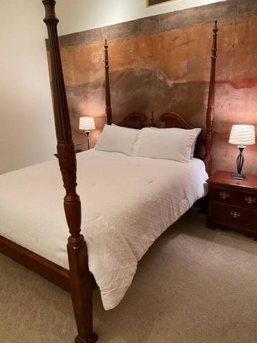 a bedroom with a wooden bed with white sheets and pillows at Adventure and Serenity in Litchfield Park Sleeps 8 in Litchfield Park
