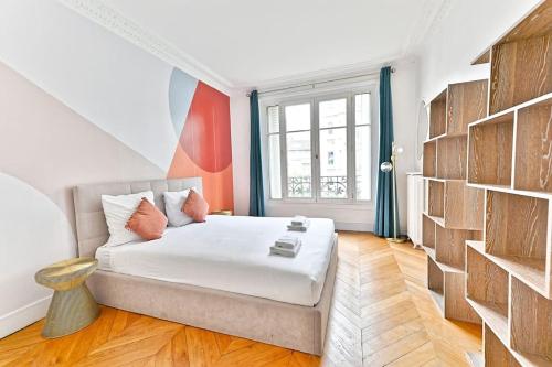 - une chambre avec un lit et un mur de livres dans l'établissement Appartement Haussmannien lumineux et central, à Paris